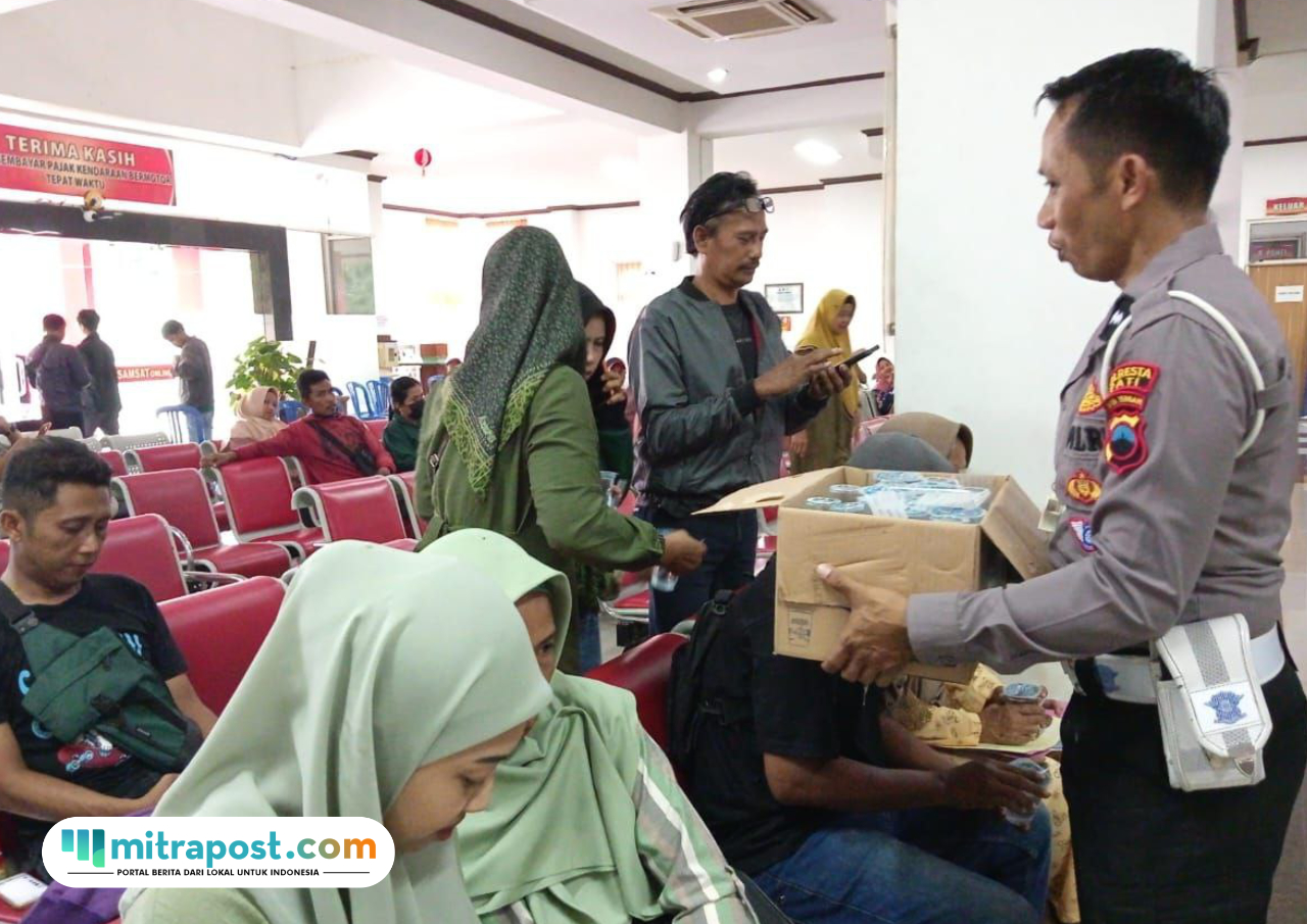 Foto: Baur STNK Samsat Pati, Aipda Sucipto saat memberikan air minum kepada masyarakat yang mau membeyar pajak kendaraan di Samsat Pati (palevioletred-jellyfish-458835.hostingersite.com/ Kafi)